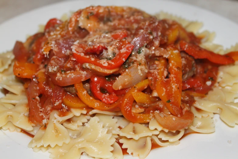 a plate of pasta covered in sauce and vegetables