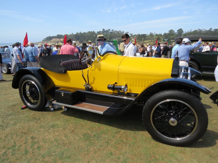 a yellow car that is parked in the grass