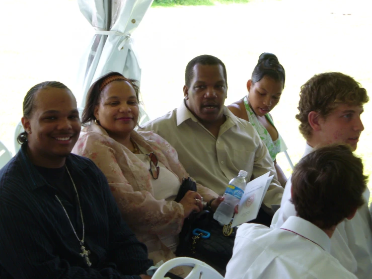 several people are sitting next to each other smiling