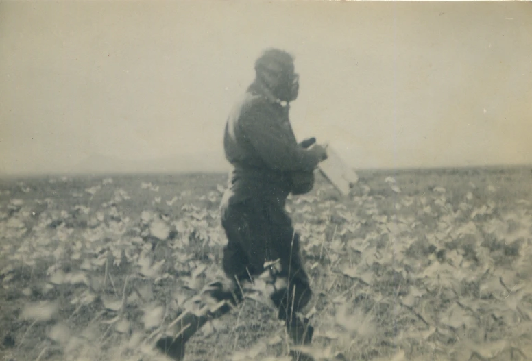 a vintage pograph of a farmer standing in a field with a pick plow