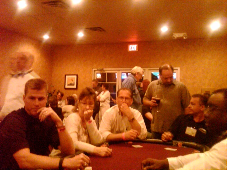 a crowd of people sitting at a poker table