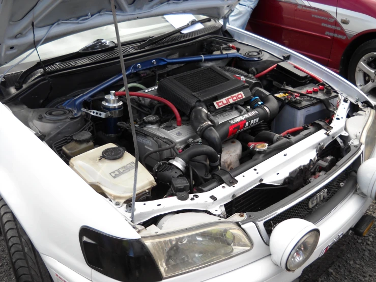 an open car trunk with the engine and wires running