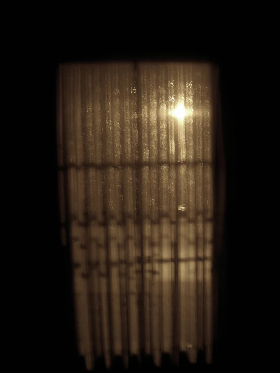 the dark window is covered in light and curtains