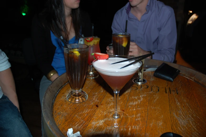 two people sit at a table filled with drinks