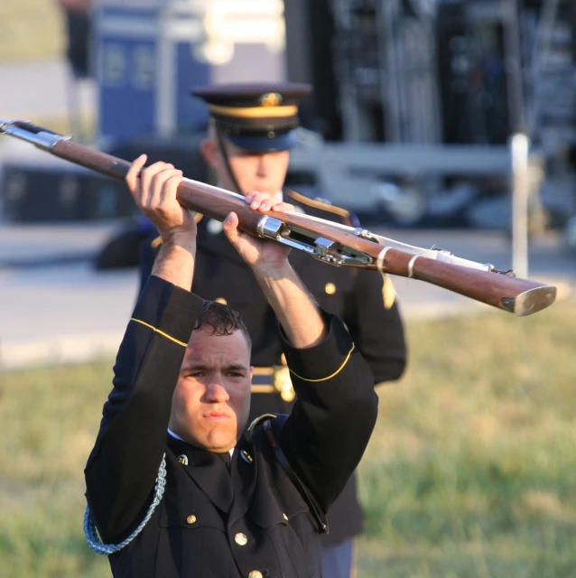 a marine in uniform holding up a rifle