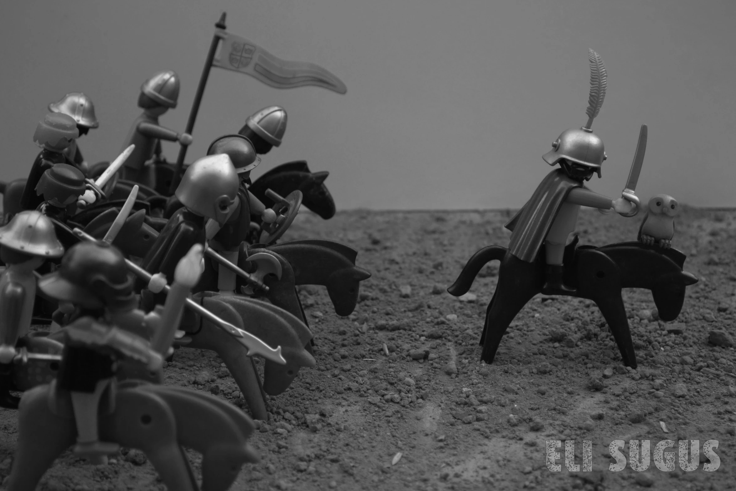 small toy soldiers on horseback in sand, all facing each other