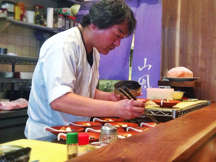 the chef is putting cheese on top of a plate