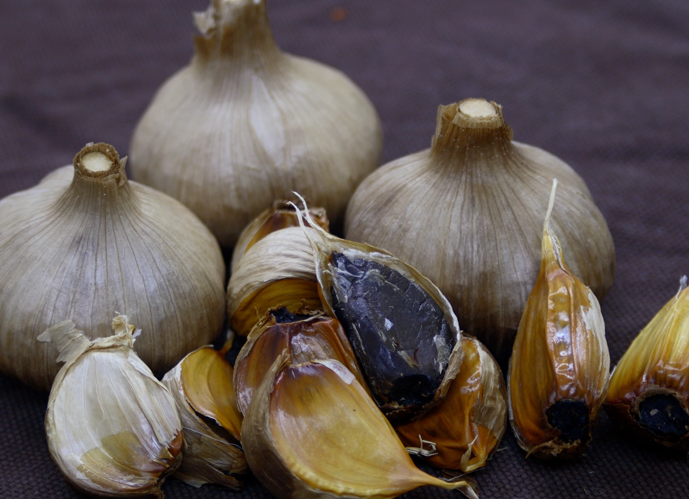 garlics and cloves sit on top of the table