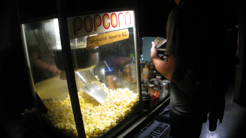 a popcorn machine with an audience in the background