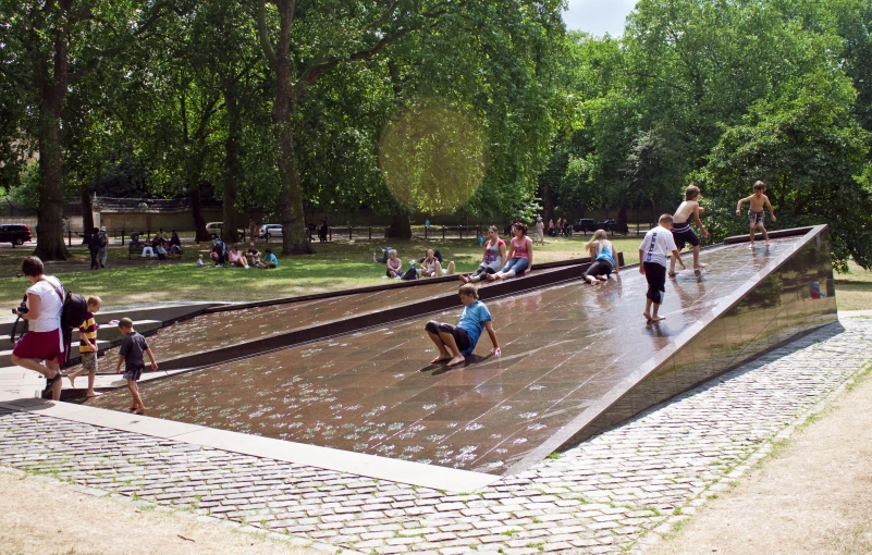 people with water and umbrellas walking down a walkway