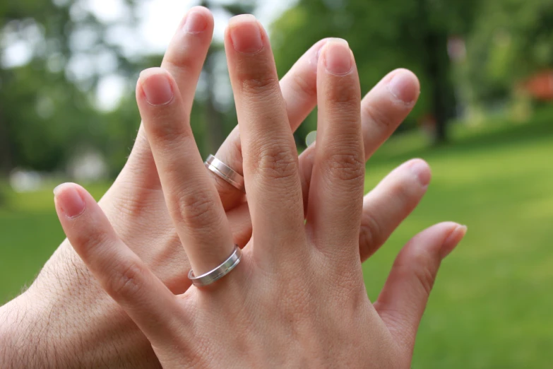 the couple holds hands together while the other holds a small ring