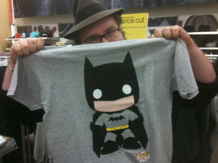 man showing off batman t shirt in shop