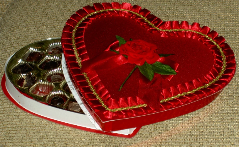 a heart shaped box with a red rose sticking out of it