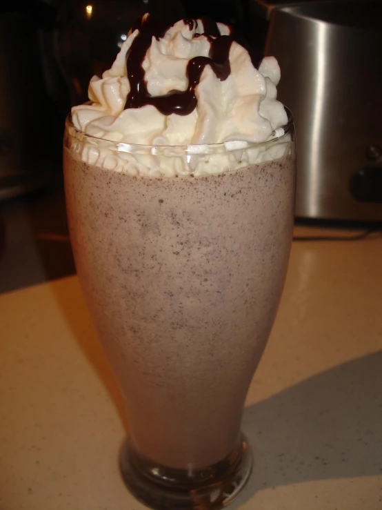 a brown drink has some whipped cream and chocolate