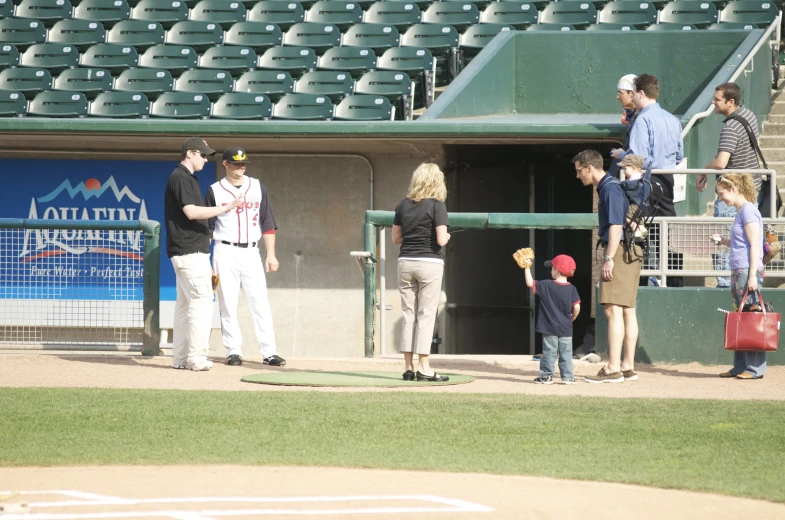 several young children are standing at the baseball diamond