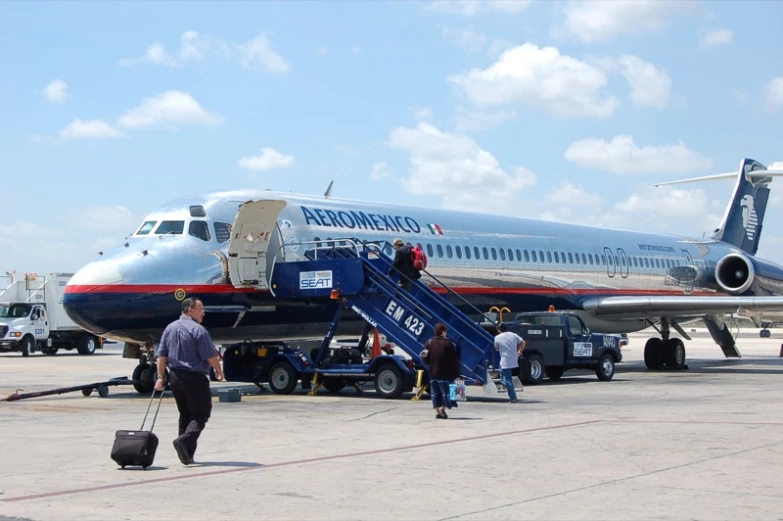 several people walking off a large blue and red plane