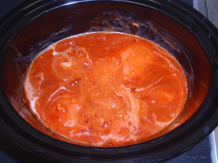 a crock pot filled with a bright colored liquid