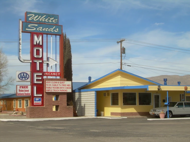 a motel with cars and sign on it