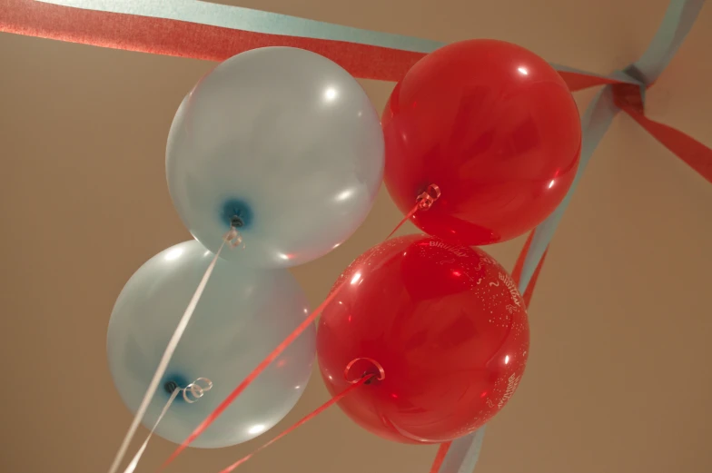 several red and white balloons attached to the ceiling