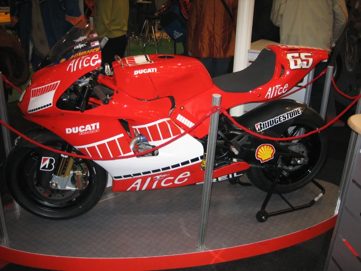 a red and white motor cycle parked inside a showroom