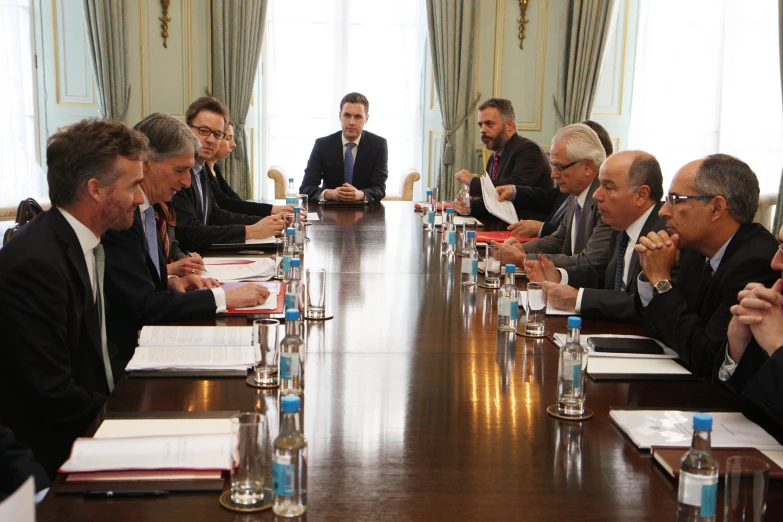 a group of men sitting around a large wooden table