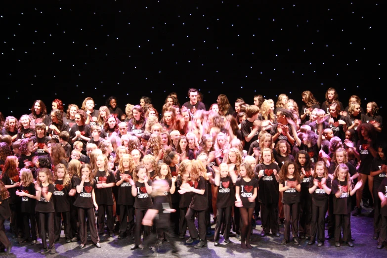 a group of people dressed in black are standing on a stage