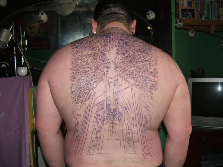 this man has many tattoos on his back