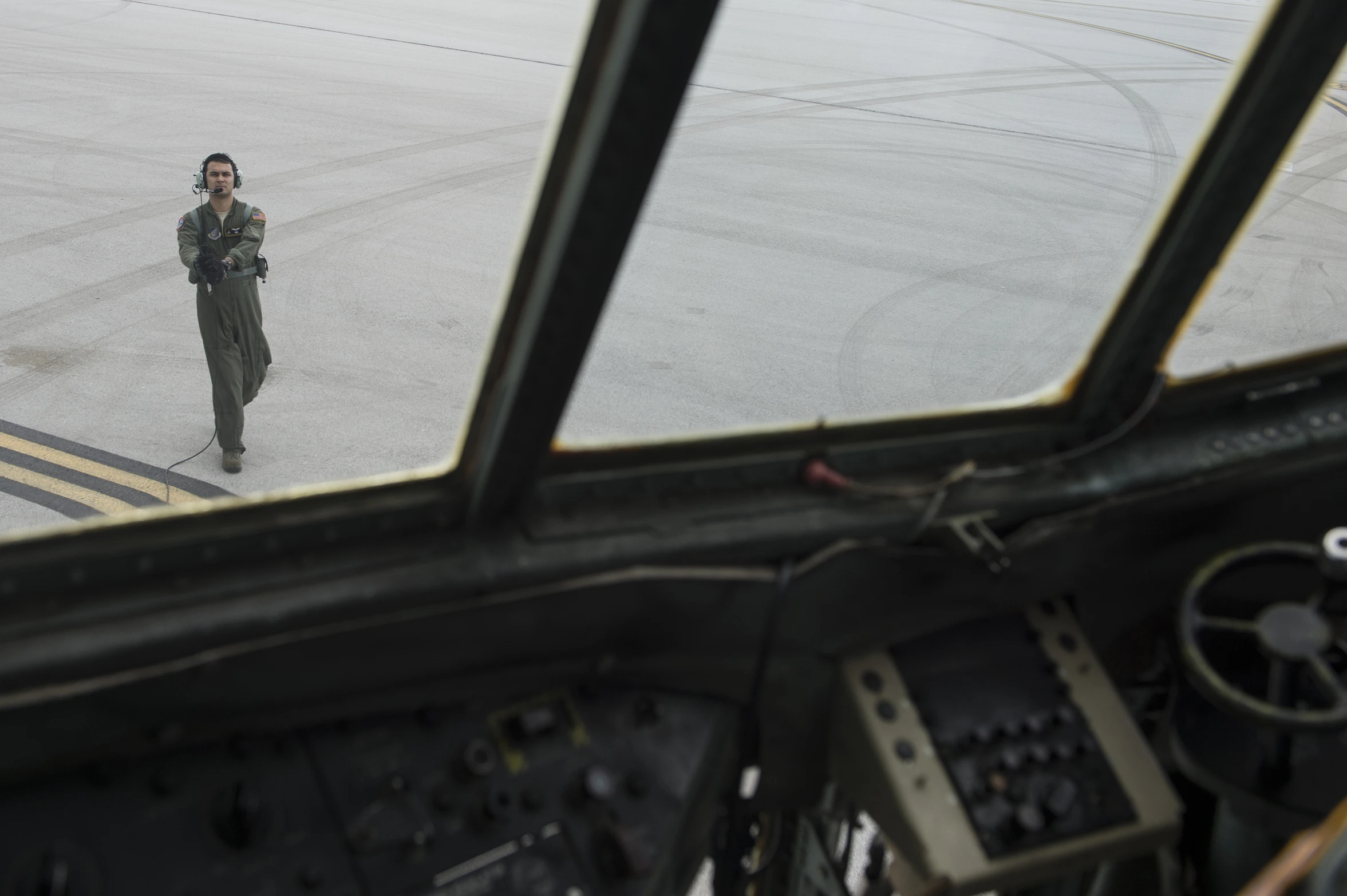 a man in military fatigues stands inside an airplane cockpit