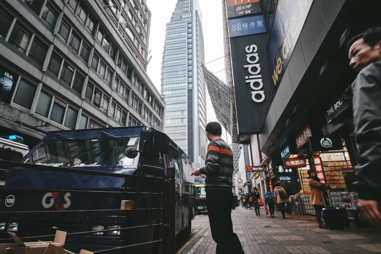 a man standing in the middle of a sidewalk near other buildings