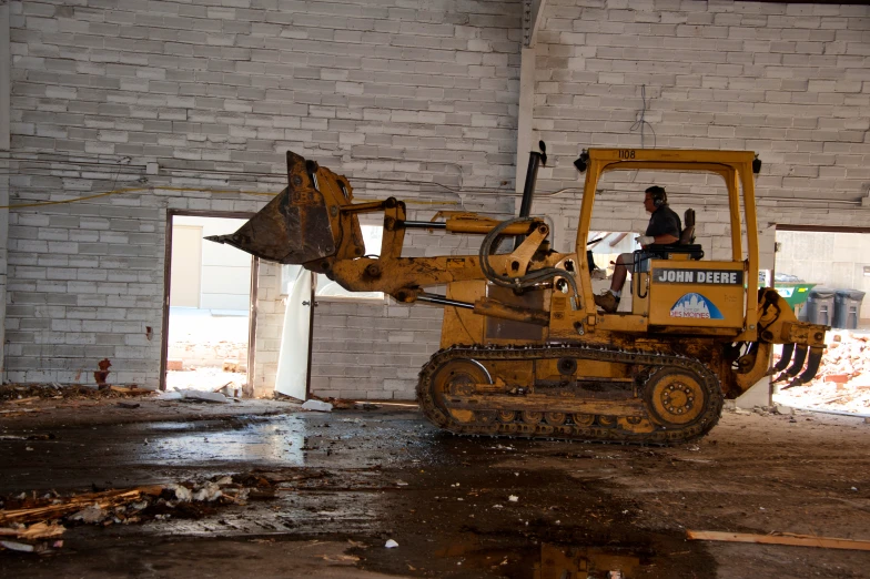 a bulldozer is in front of a brick wall in the dark