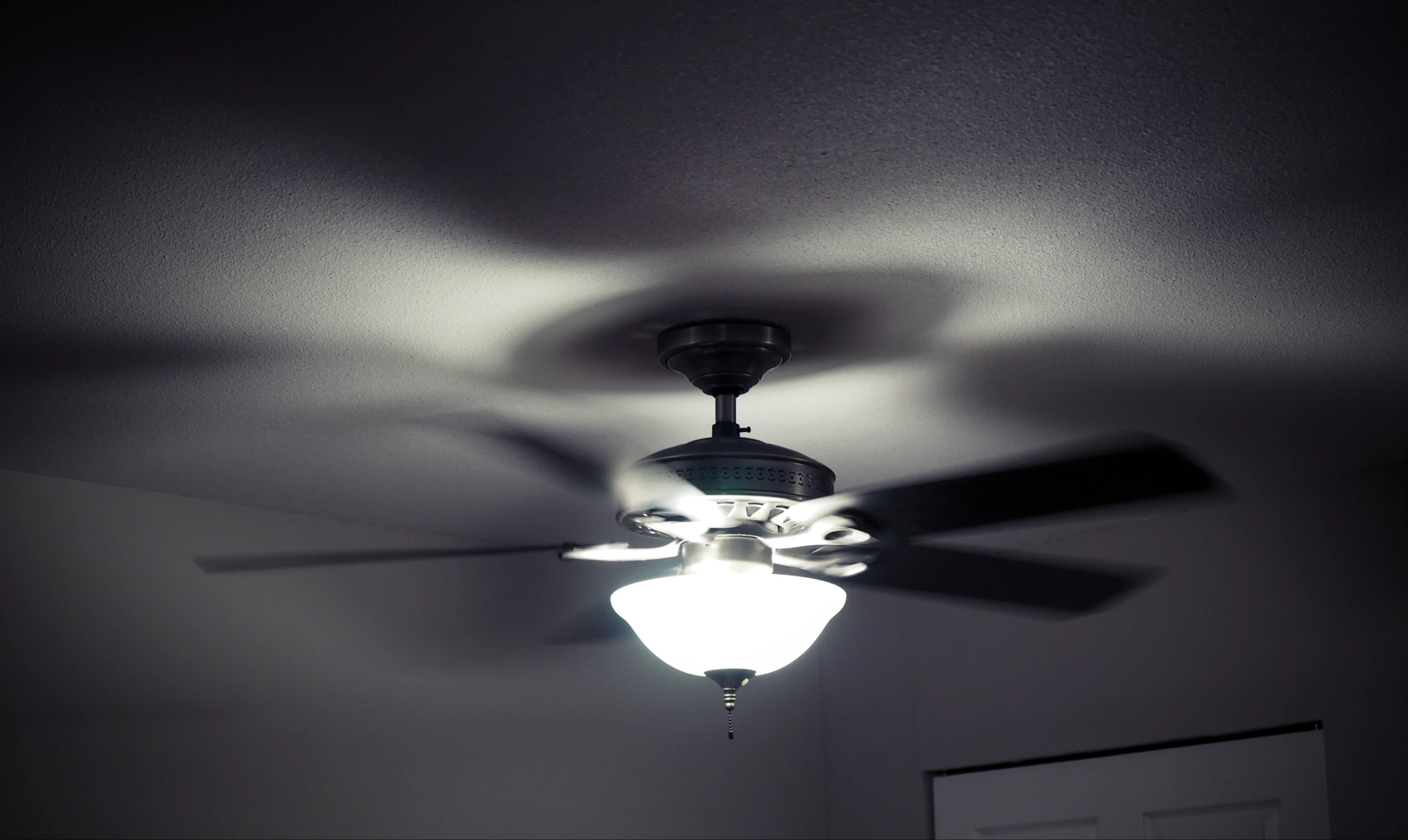 a light is mounted on a ceiling fan