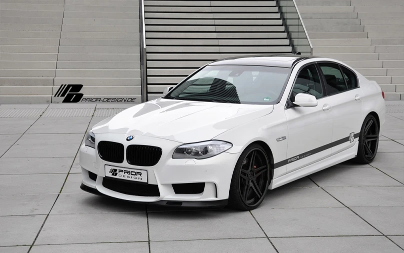white bmw car parked near a large metal staircase