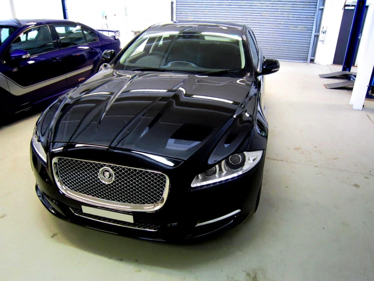 a black jaguar parked next to a blue jaguar