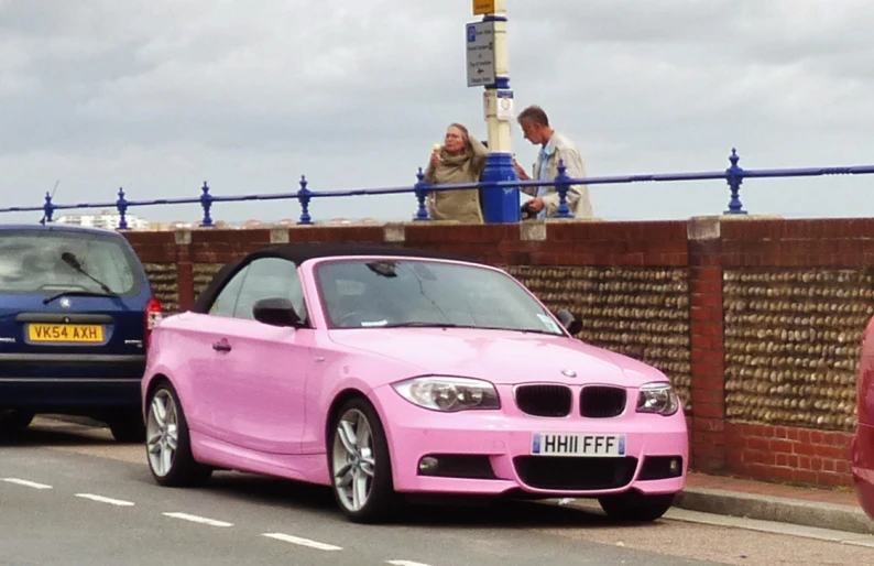 a pink car parked next to a blue car