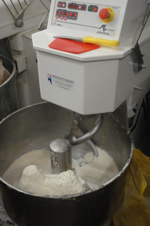 white and red mixer in mixing bowl with a yellow sponge