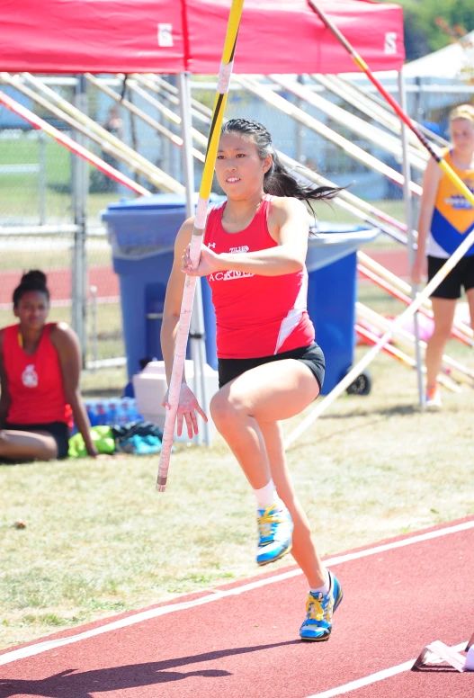 a girl runs on a track during the day