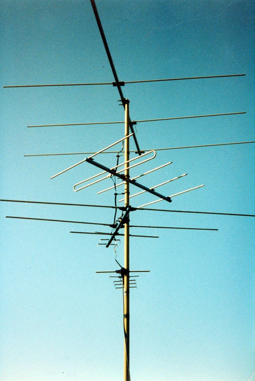 many antennas are attached to poles against the blue sky