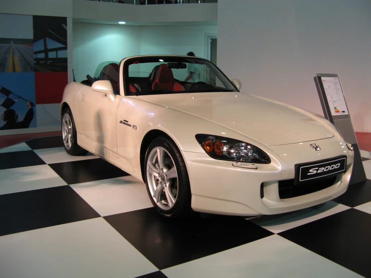 a very nice white sports car on a checkered floor
