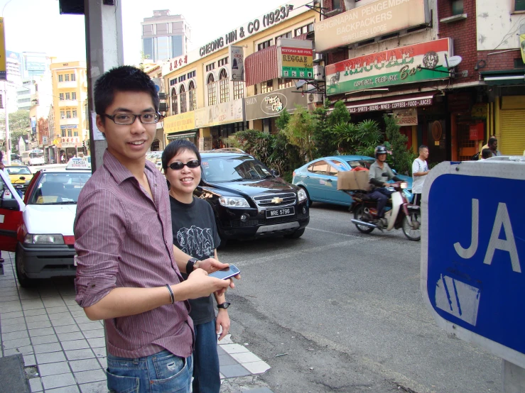 a couple standing in front of a sign that says ja in front of them