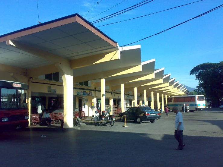 people standing outside the entrance of a large bus station