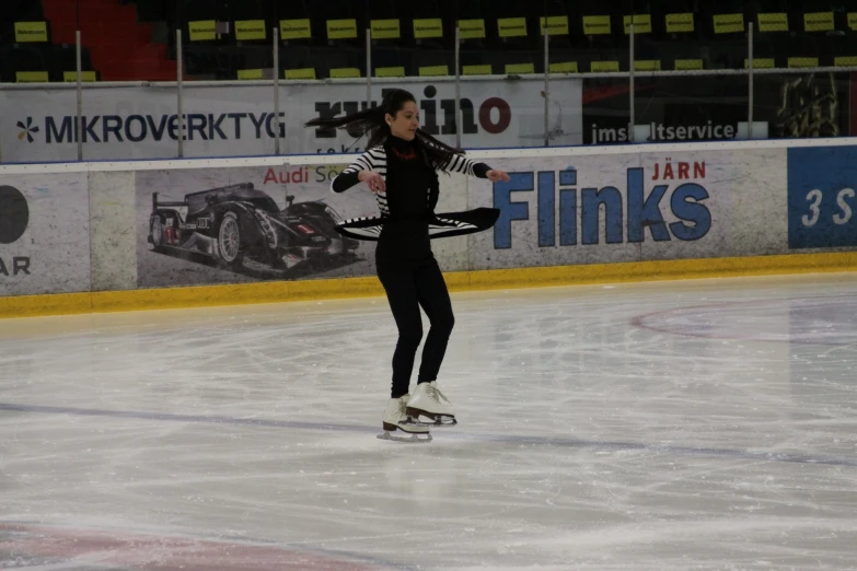 a female skate boarder dressed in black riding on ice