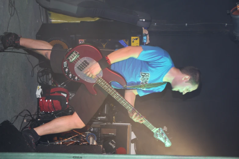 a man sitting on the ground playing an electric guitar