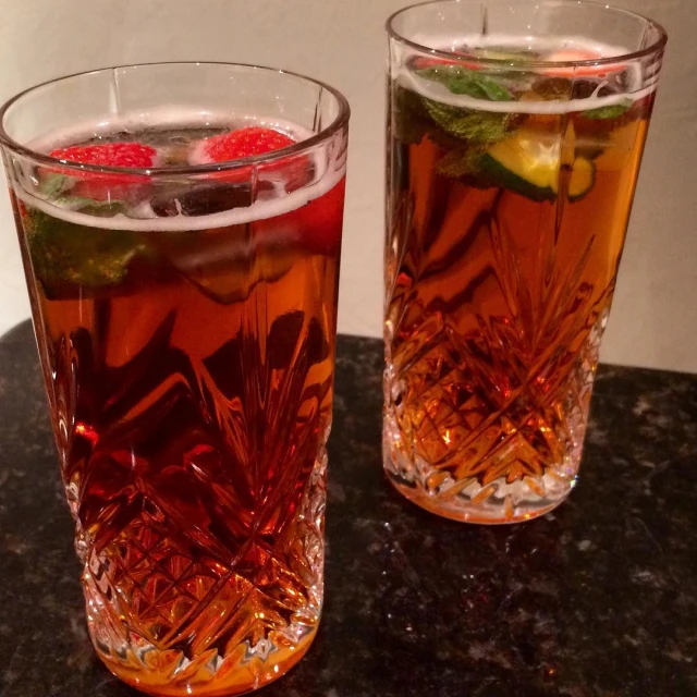 two glasses of ice tea with raspberries and lime