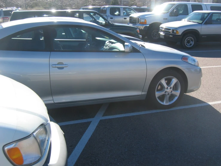 a silver car in parking lot full of cars