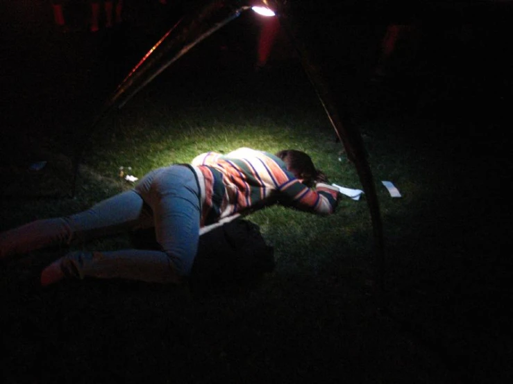 a woman is laying on the ground in the dark