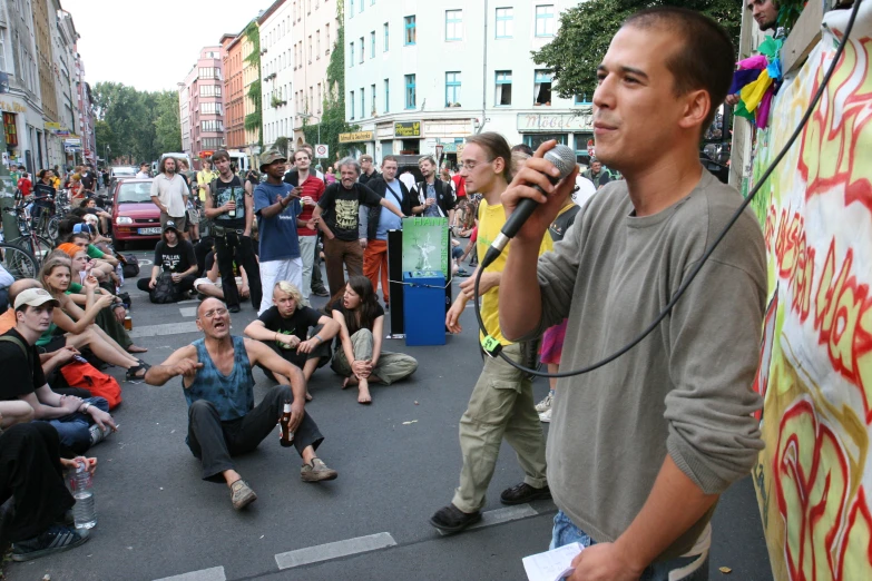 a man holding a microphone standing in the middle of a crowd