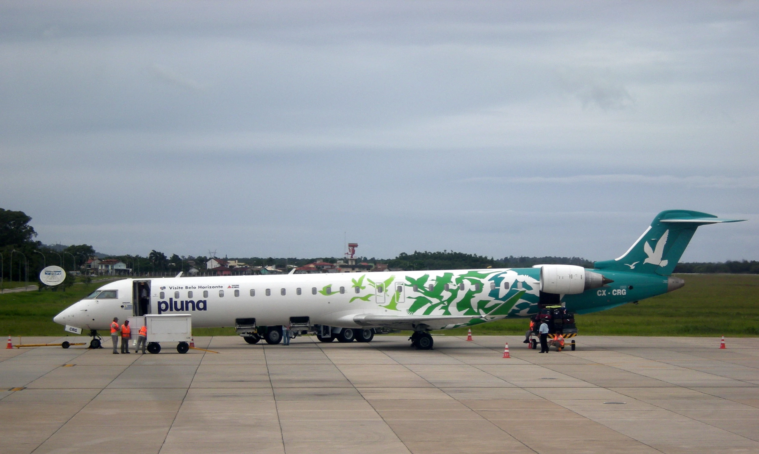 a large green and white plane is on the runway