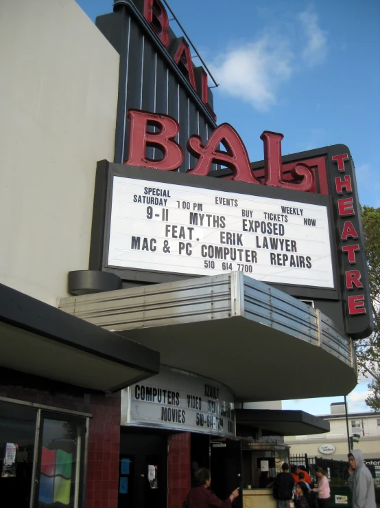 people are walking in front of a marquee