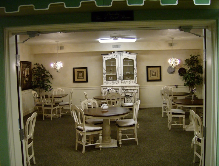 an empty restaurant table set with white chairs
