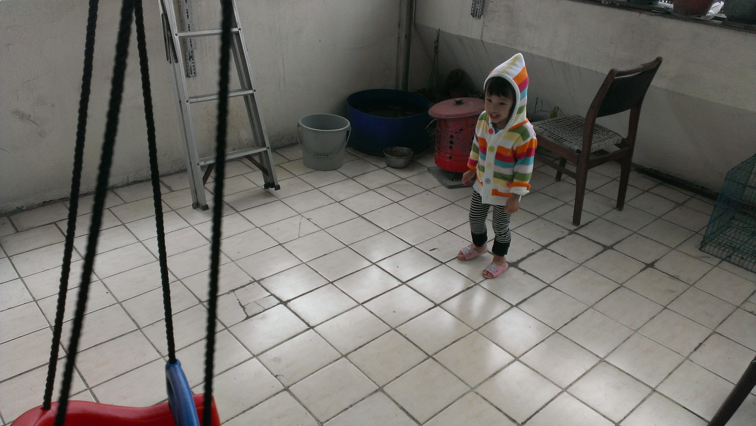 young child with a clown hat on is standing in a room